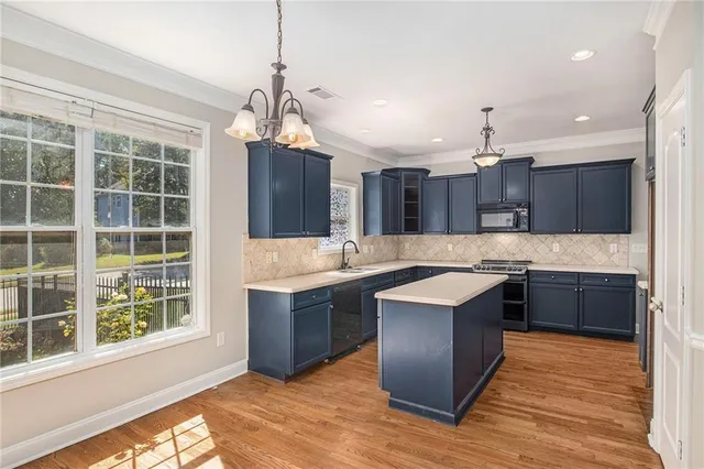 a large kitchen with kitchen island a sink stainless steel appliances and cabinets