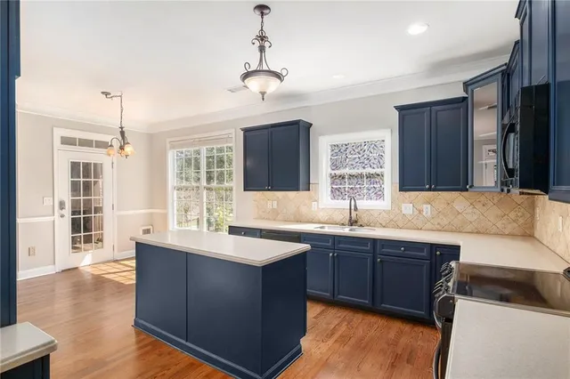 a kitchen with a sink a counter space appliances and cabinets