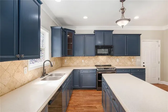 a kitchen with a sink a stove and cabinets