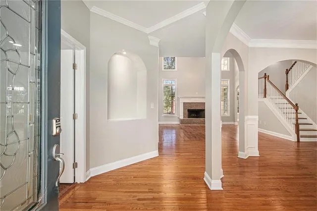 a view of a hallway with wooden floor and staircase