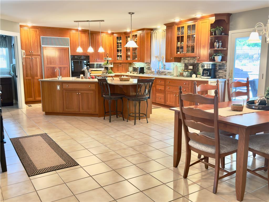 4982 Abbey Road Coplay, PA 18037 - Photo 14 of 55 Rich wood cabinetry and expansive tile flooring define this warm, open kitchen and dining area.