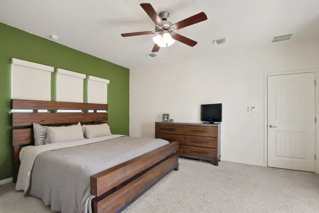 a bedroom with a bed and a ceiling fan