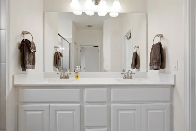 a bathroom with a double vanity sink and a mirror