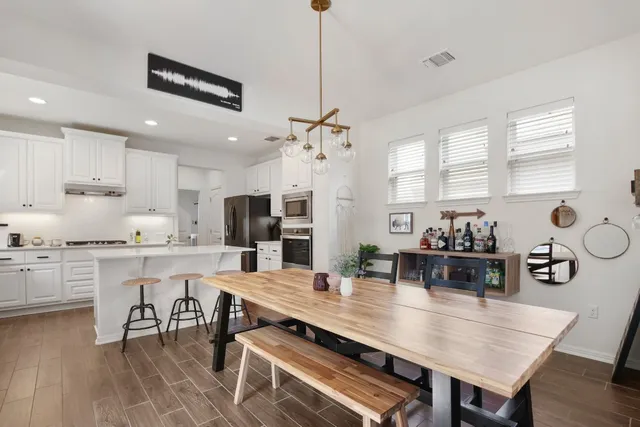 a large kitchen with kitchen island a table and chairs in it