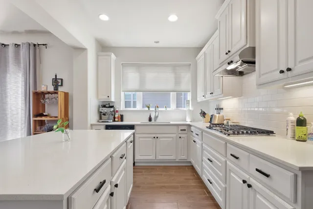 a kitchen with stainless steel appliances a sink stove and cabinets