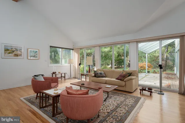 a living room with furniture a rug and a large window