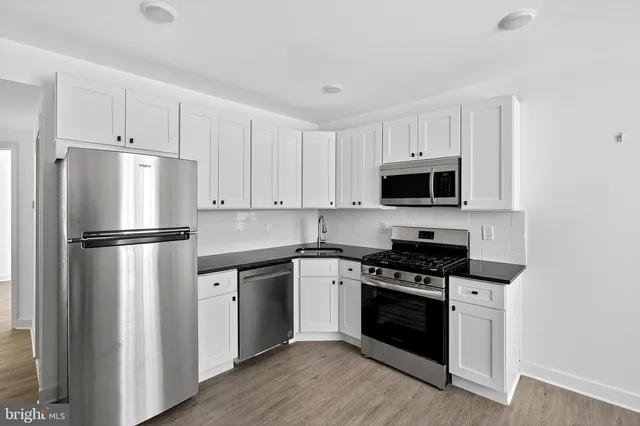 a kitchen with white cabinets and stainless steel appliances