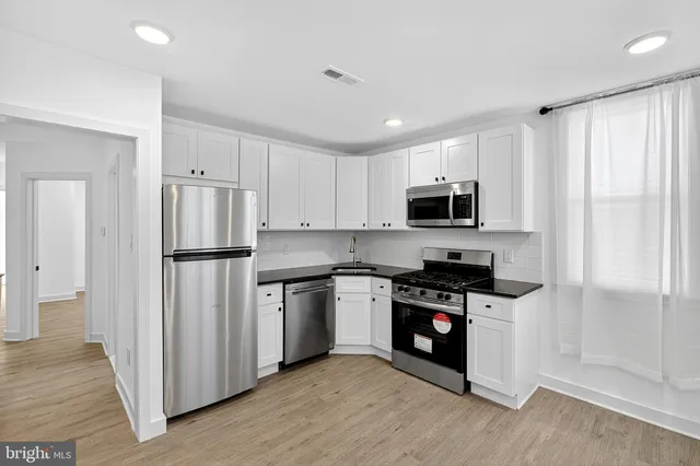 a kitchen with stainless steel appliances a refrigerator stove and microwave
