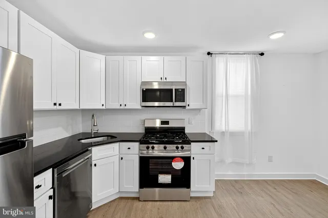 a kitchen with stainless steel appliances a stove a sink and a microwave
