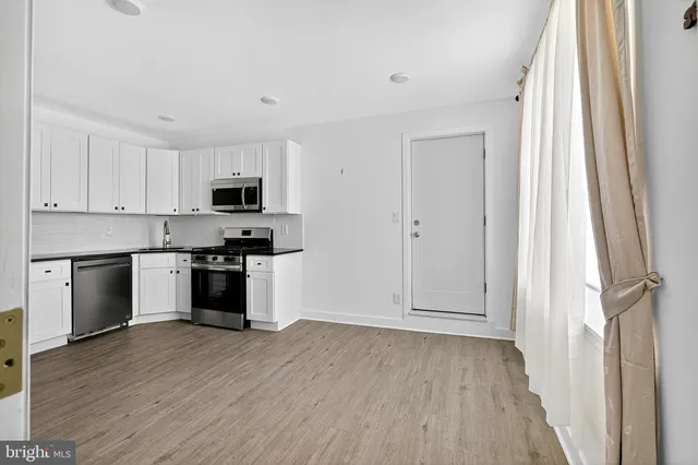 a kitchen with granite countertop white cabinets and stainless steel appliances
