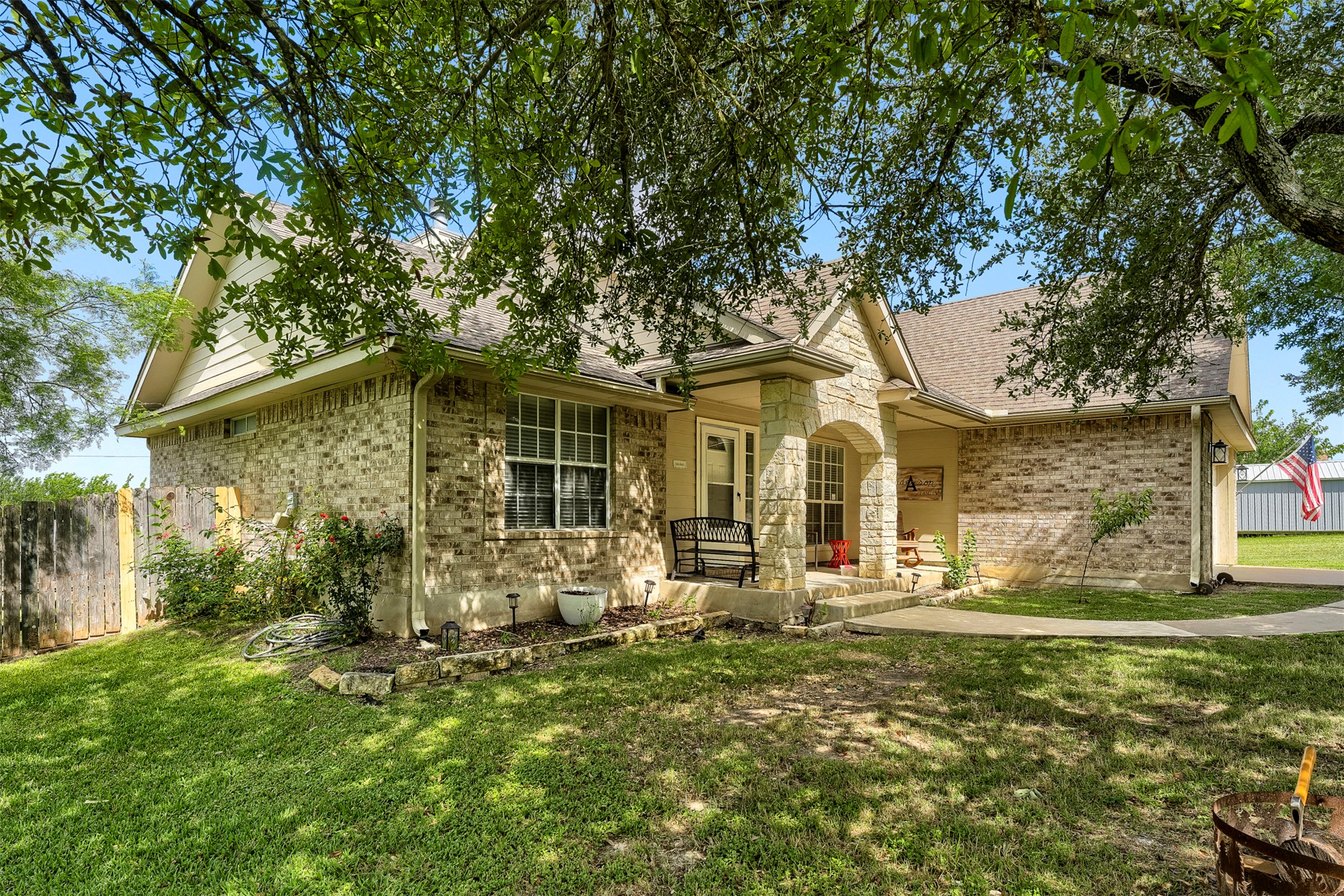 1105 2nd Street Jarrell, TX 76537 - Photo 2 of 27 A classic brick and stone facade welcomes guests with a charming covered porch and verdant lawn.