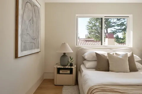 a bedroom with a bed and a large window