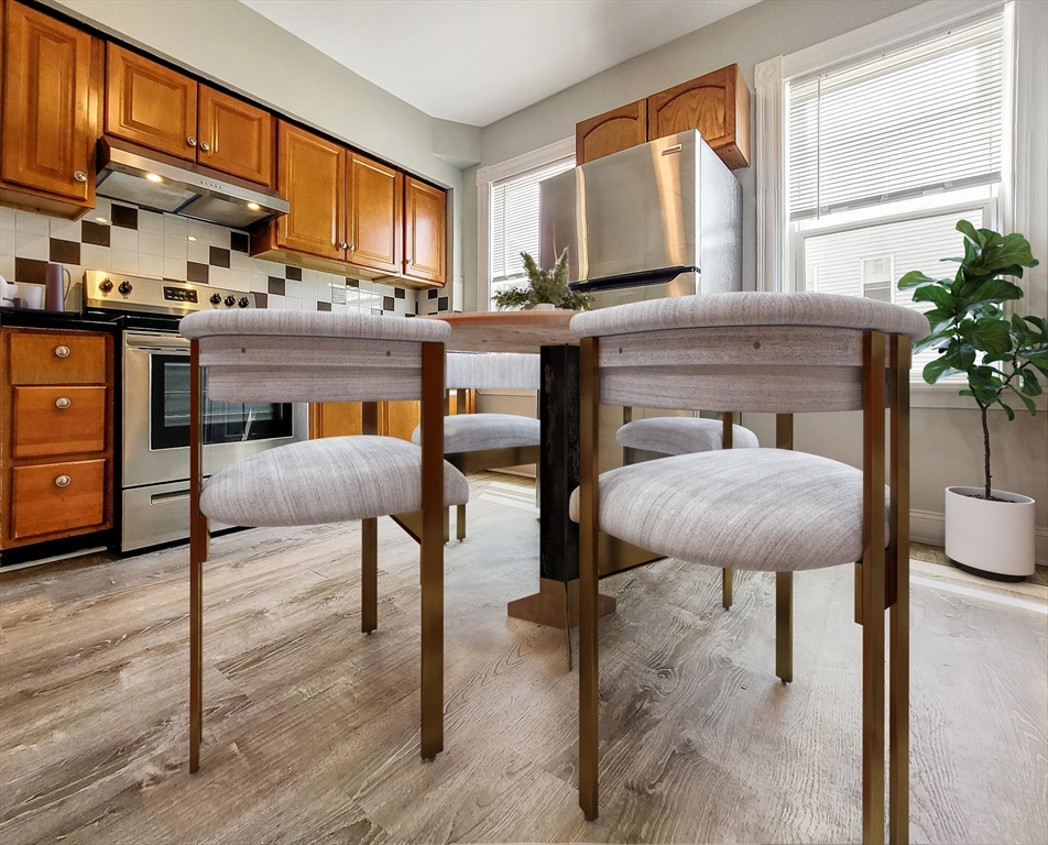 a kitchen with stainless steel appliances granite countertop table chairs sink and cabinets