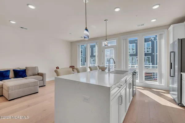 a large kitchen with kitchen island a island a stove a sink a dining table and chairs