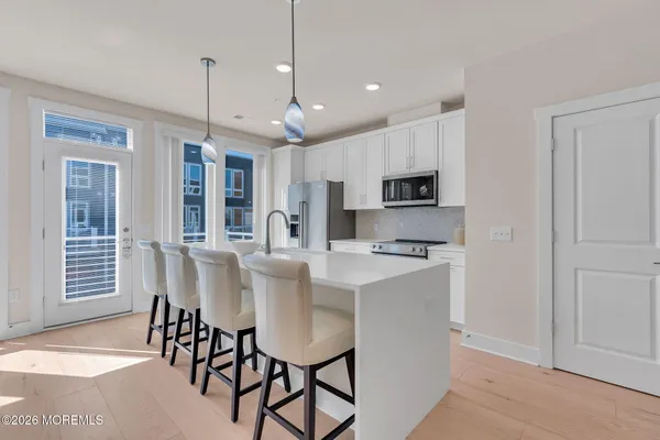 a kitchen with a dining table chairs sink and refrigerator