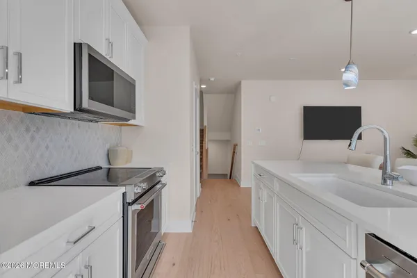 a kitchen that has a sink cabinets counter space and stainless steel appliances