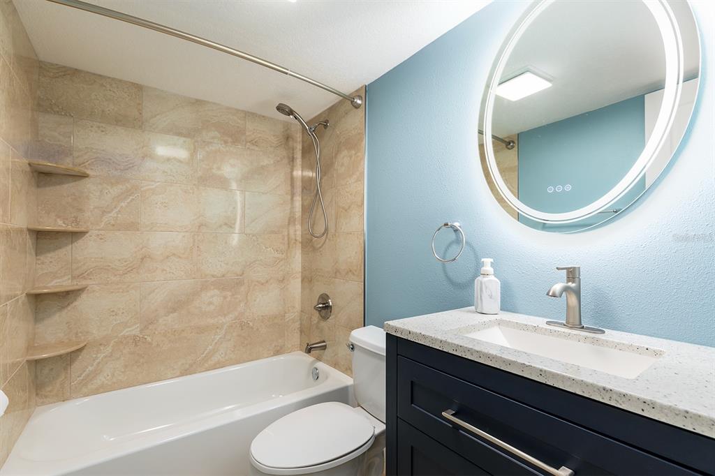 4822 South Conway Road, Unit 127 Orlando, FL 32812 - Photo 13 of 15 a bathroom with a granite countertop toilet sink and mirror