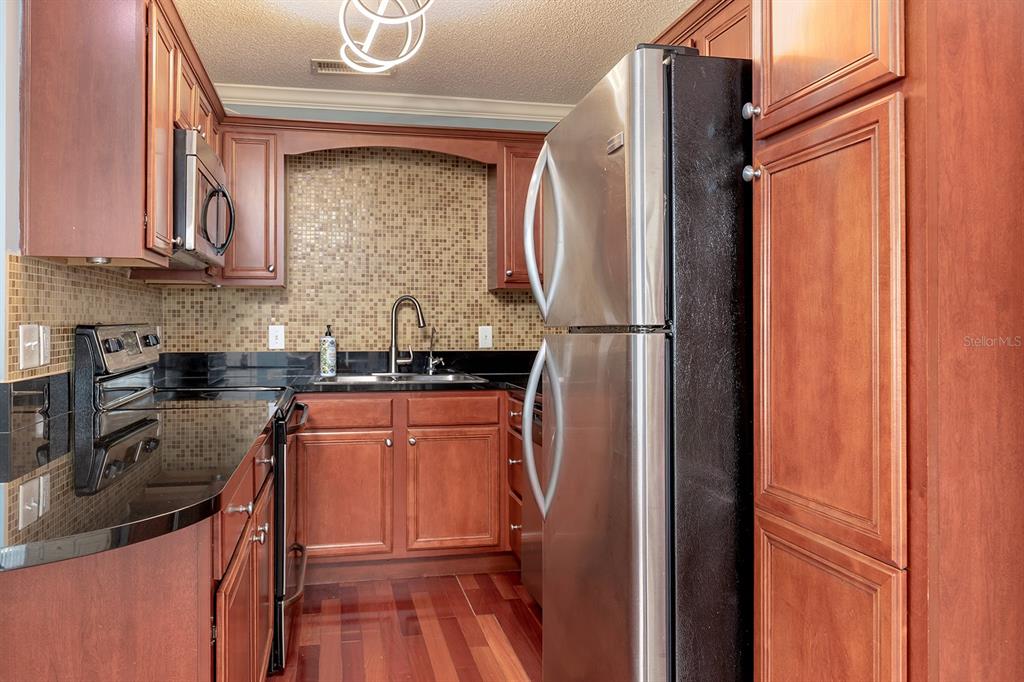 4822 South Conway Road, Unit 127 Orlando, FL 32812 - Photo 6 of 15 a kitchen with stainless steel appliances granite countertop a refrigerator and a stove top oven