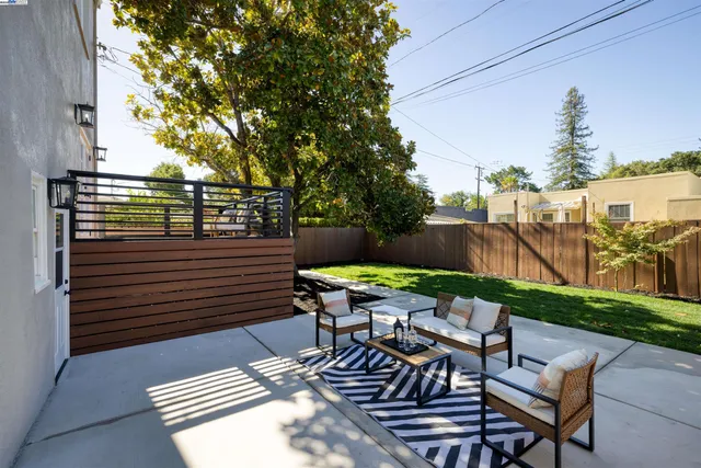 a view of a patio with table and chairs with wooden floor and fence