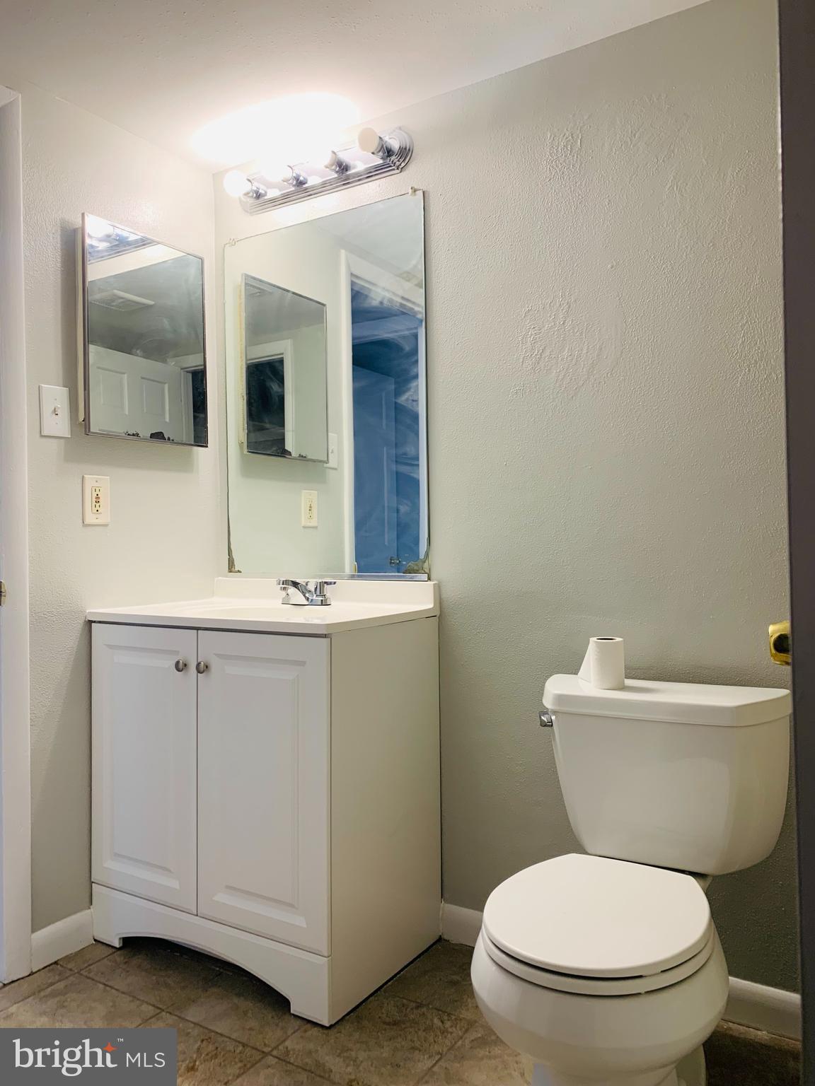 8875 Tamebird Court, Unit J Columbia, MD 21045 - Photo 14 of 15 a bathroom with a toilet a sink and mirror
