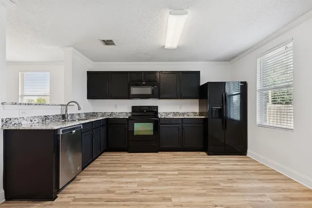 a kitchen with stainless steel appliances granite countertop a refrigerator and a sink