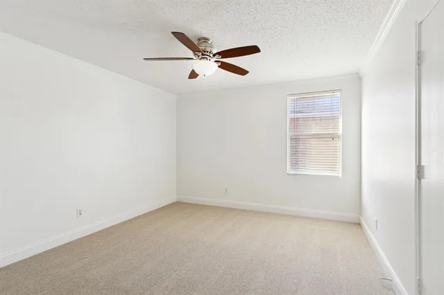 an empty room with a window and ceiling fan