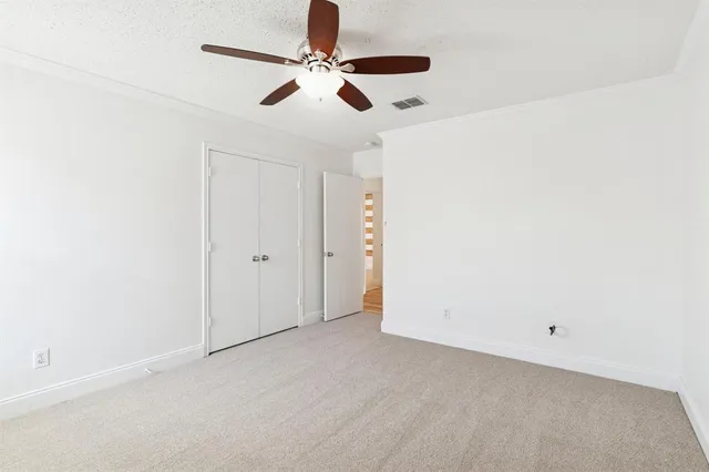 an empty room with a ceiling fan and a window