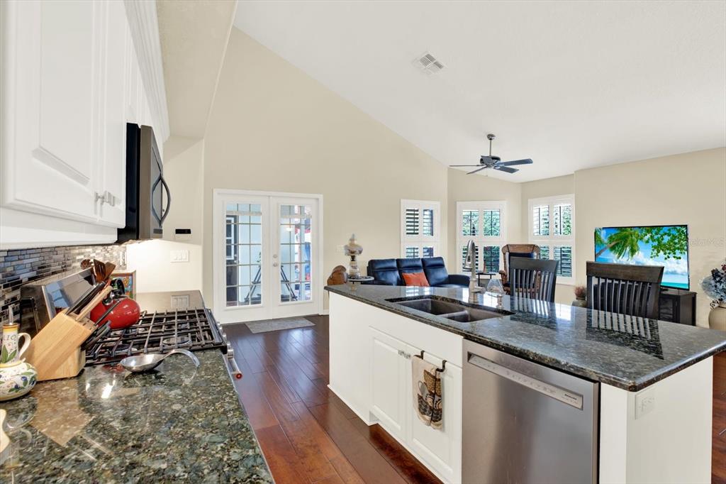 2021 Meadow Rue Court Trinity, FL 34655 - Photo 11 of 41 a kitchen with stainless steel appliances granite countertop a sink dishwasher stove top oven and cabinets with wooden floor