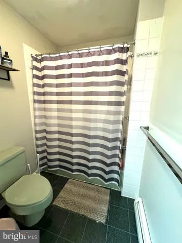 a view of a backyard with large tree and wooden fence