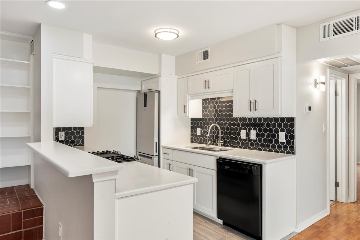 505 West 7th Street, Unit 313 Austin, TX 78701 - Photo 7 of 30 Kitchen featuring visible vents, dishwasher, freestanding refrigerator, and a sink