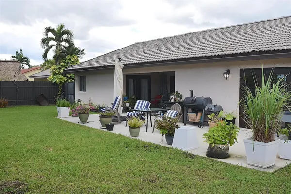 a view of a backyard with sitting area and garden