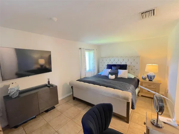 a bedroom with a bed and flat screen tv