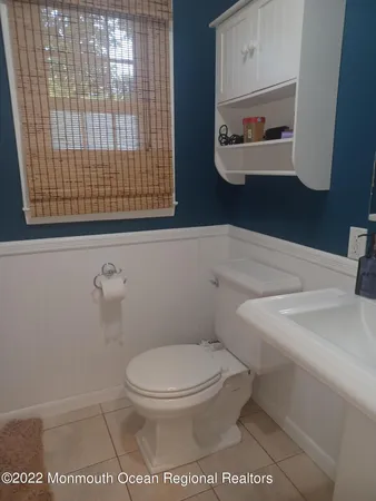 a bathroom with a toilet and a picture of a sink