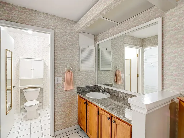 a spacious bathroom with a granite countertop sink and a mirror