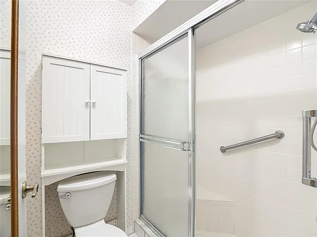 a bathroom with a toilet and a shower