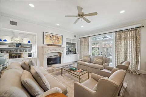 a living room with furniture a large window and a fireplace