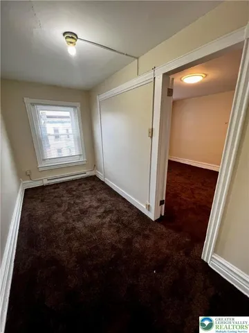en empty room with window and hardwood floor