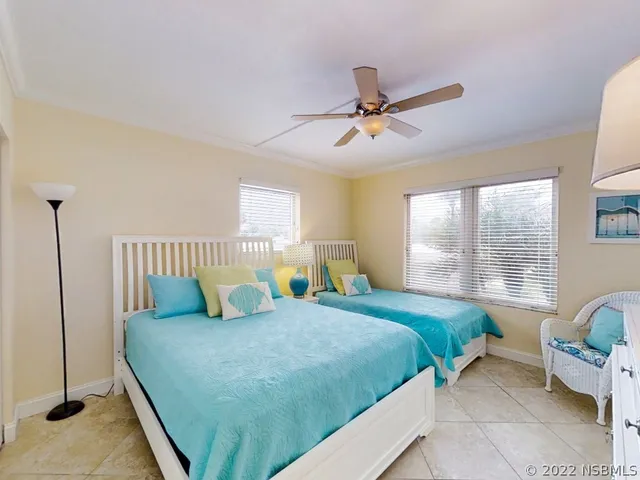 a bedroom with a bed and large windows