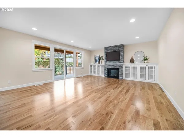 a view of empty room with wooden floor and fireplace