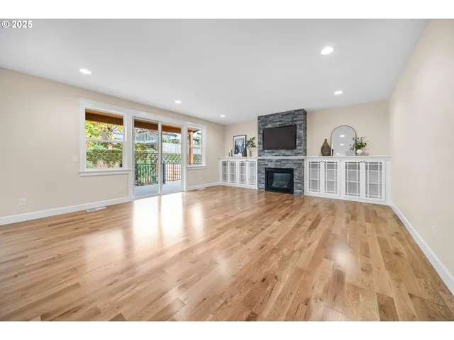 a view of empty room with wooden floor and fireplace