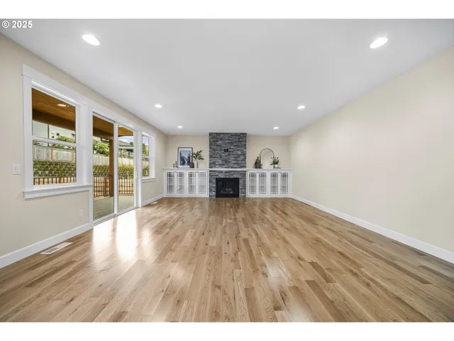 a view of empty room with a fireplace and wooden floor