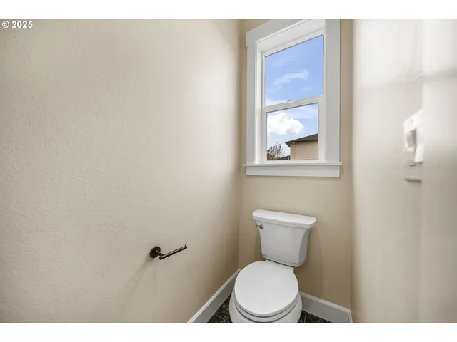 a bathroom with a toilet a sink and a window