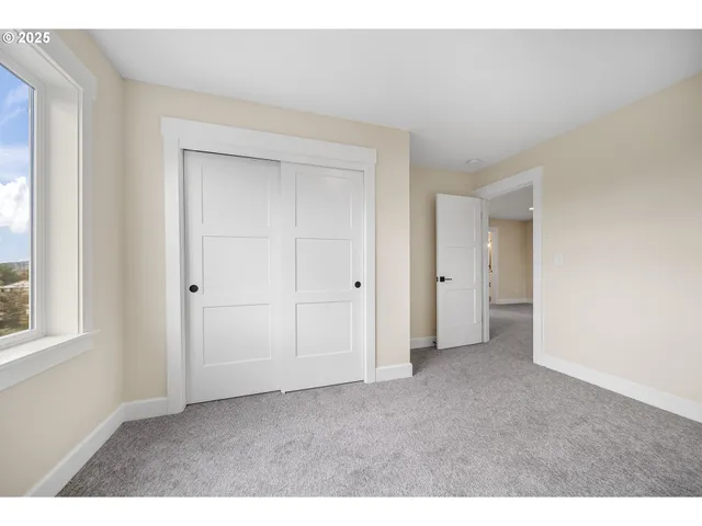 an empty room with windows and closet