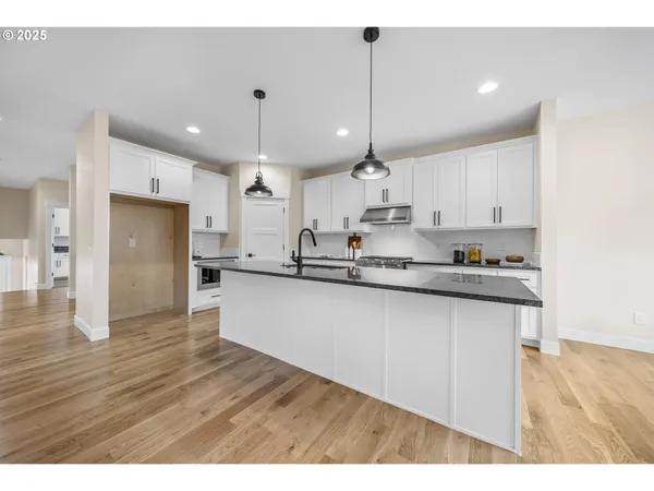 a open kitchen with stainless steel appliances granite countertop a refrigerator a sink and a oven