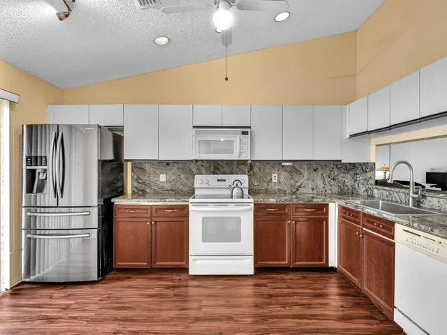 a kitchen with stainless steel appliances granite countertop a stove a sink and a refrigerator