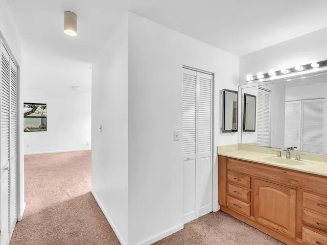 a spacious bathroom with a granite countertop sink a mirror and a shower