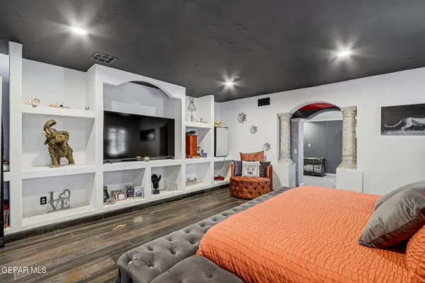 a bedroom with a bed a flat screen tv and dresser