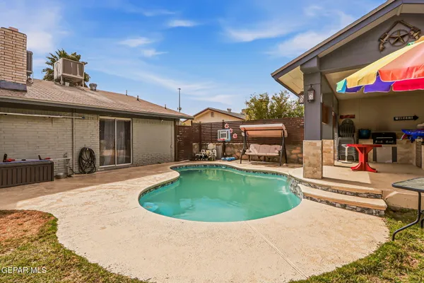 an outdoor space with swimming pool and furniture