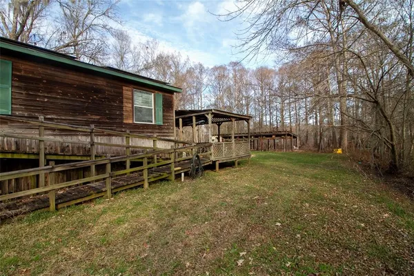 a view of a house with backyard and wooden fence