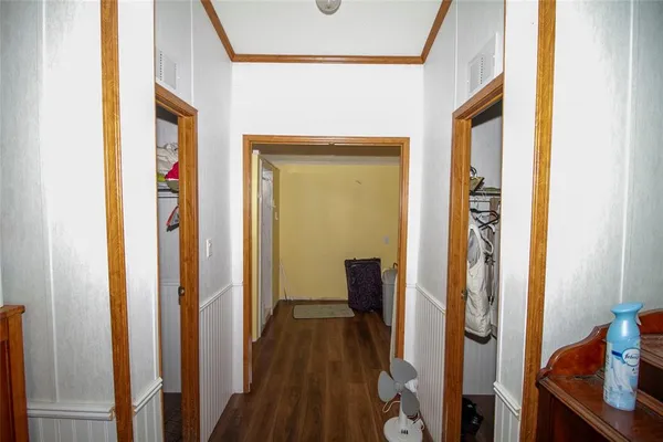 a view of a hallway with wooden floor and staircase
